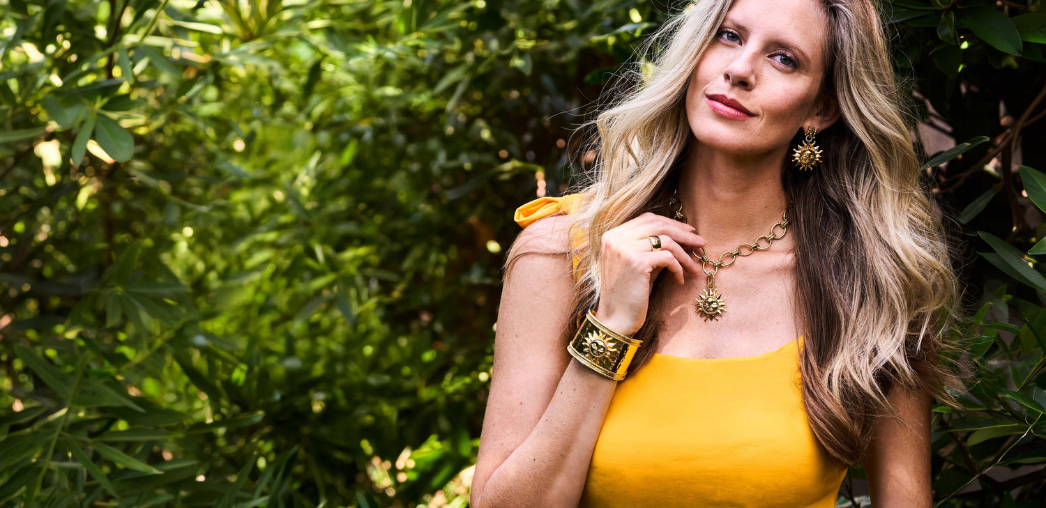 Woman in a yellow dress standing in front of green foliage