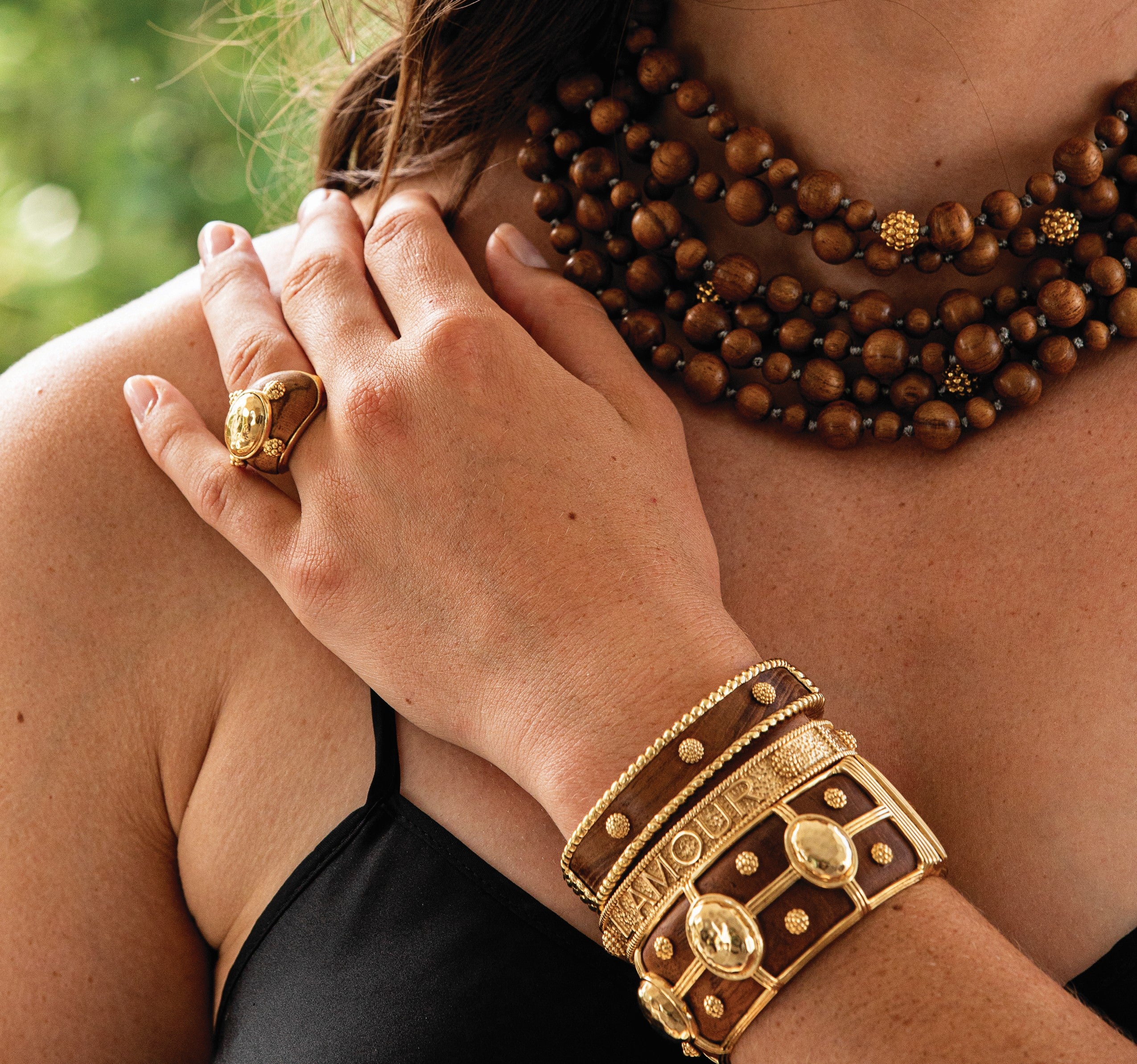 Image of women with teak and gold jewelry