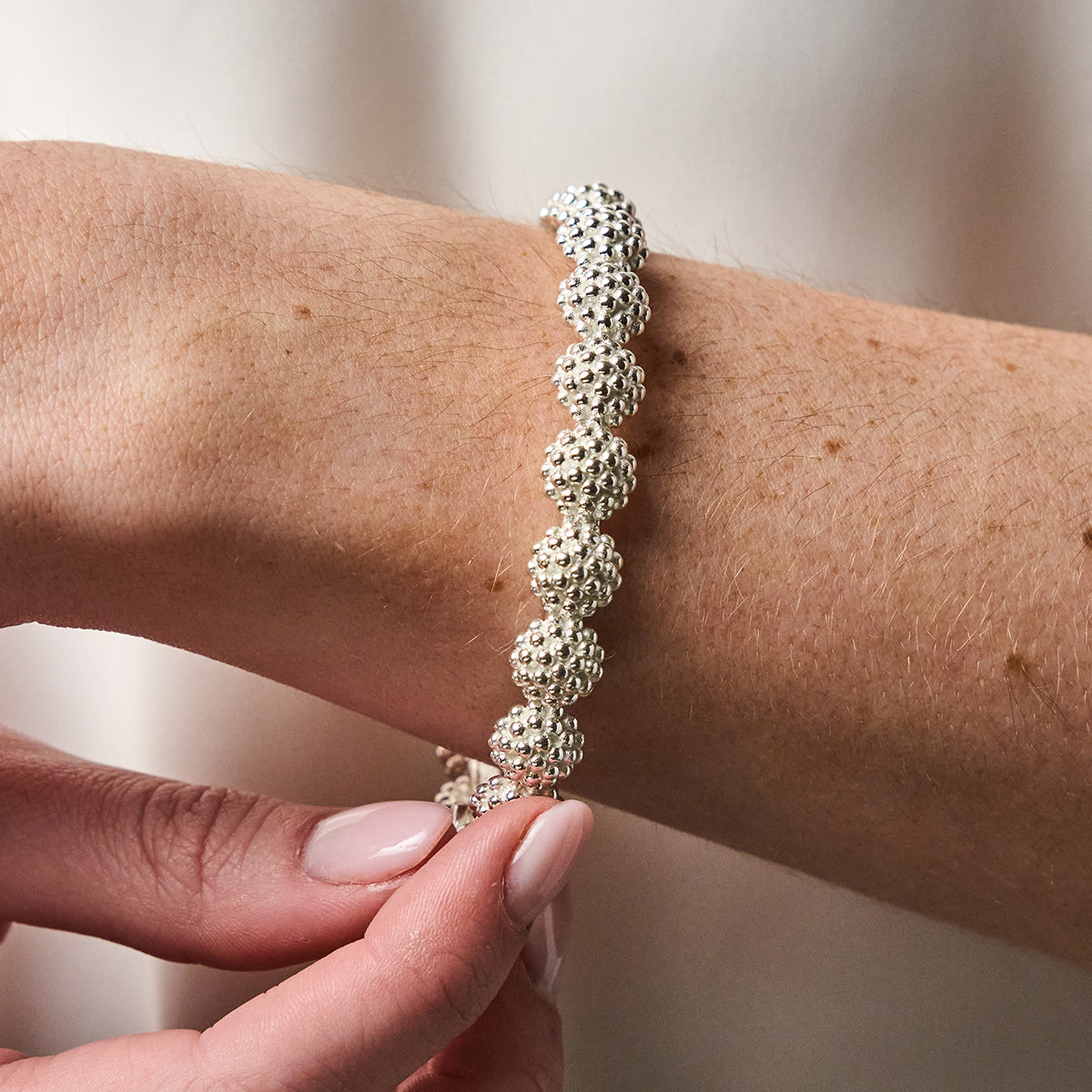Berry Eternity Hinged Bangle, S/M - Silver close up of bracelet on wrist 