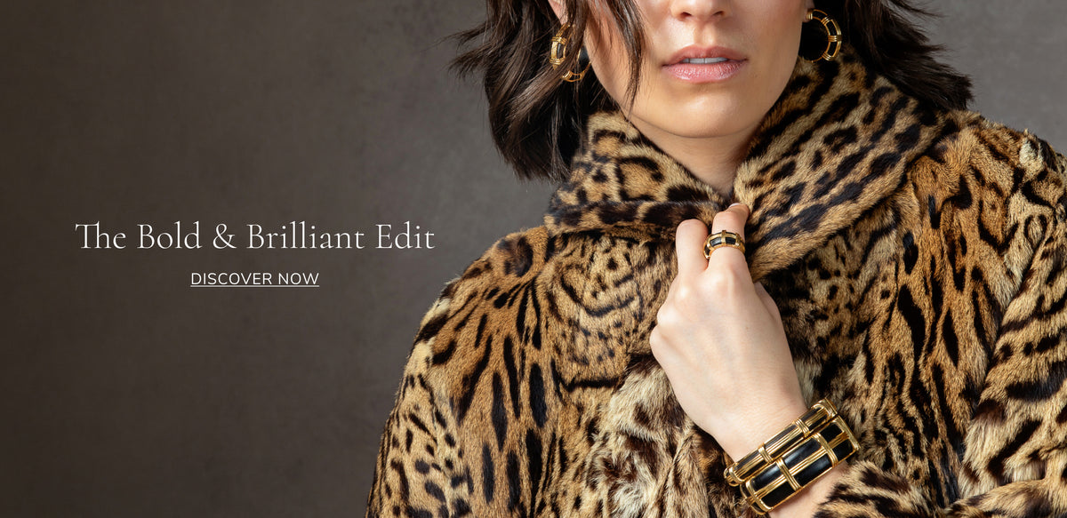 A close-up lifestyle shot of a model wearing a luxurious leopard-print fur coat, gold hoop earrings, and a chunky gold ring, set against a dark textured background with the text 'The Bold & Brilliant Edit' on the left.
