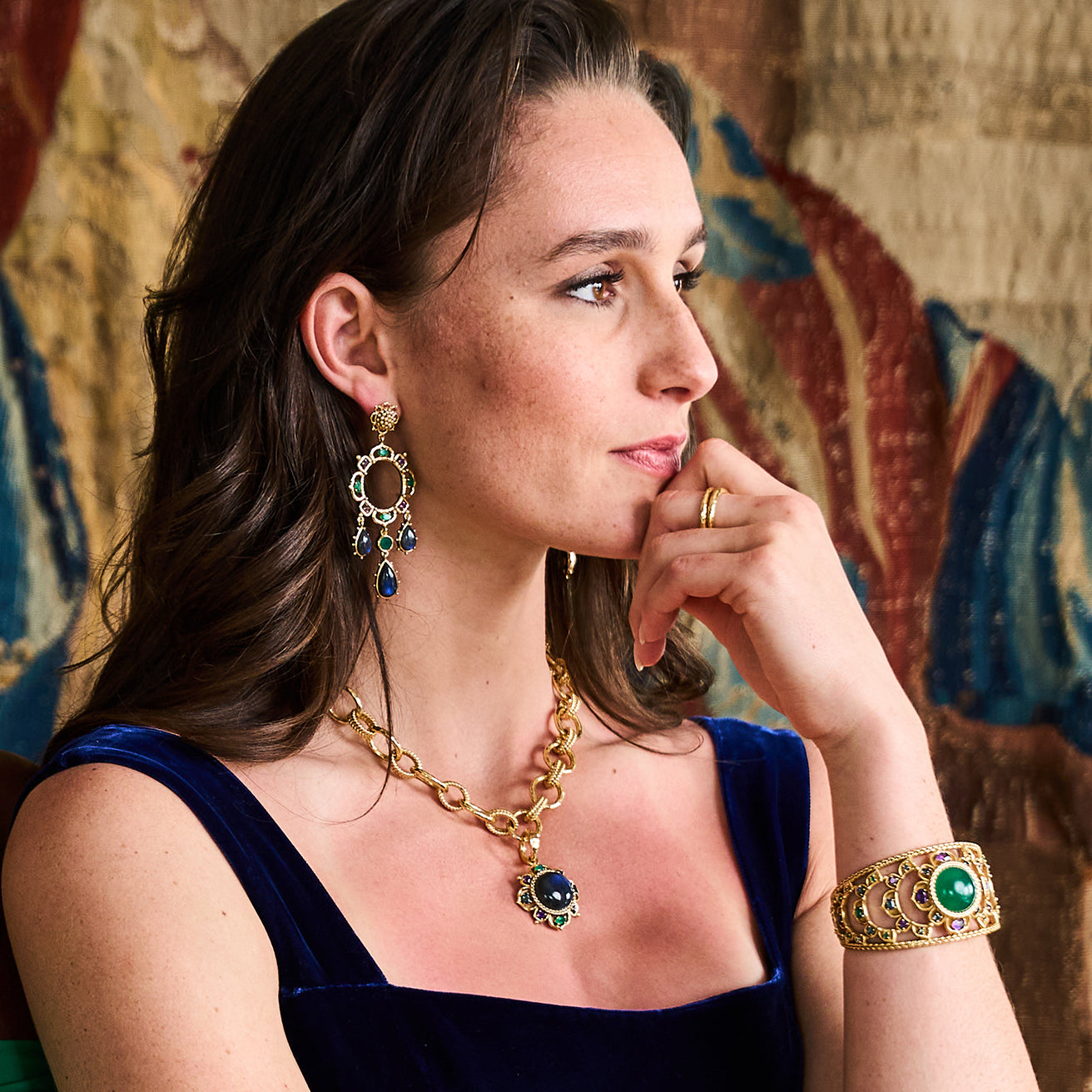 Woman wearing gold jewelry with gemstones 