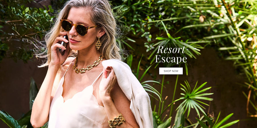 Model wearing bamboo collection from capucine de wulf in a garden. Image has text overlay saying "resort escape - shop now."