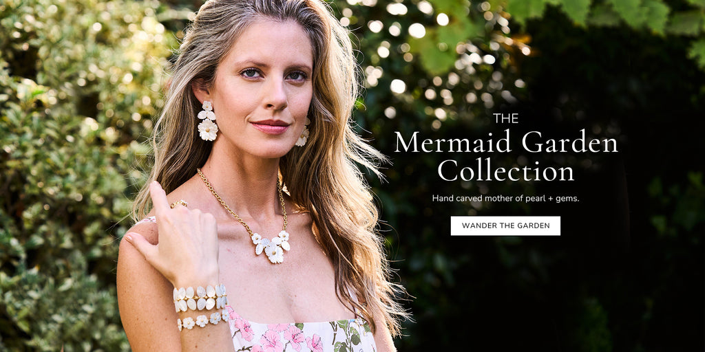 Image with text overlay saying 'The Mermaid Garden Collection. Hand carved mother of pearl gems. Wander the garden'. Image shows a woman slightly smiling with floral jewelry. 