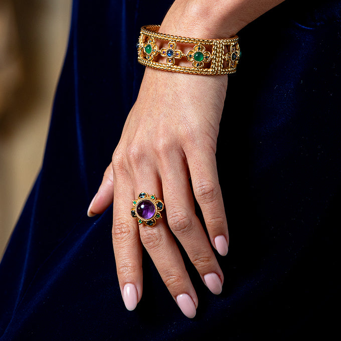 Gold bracelet and ring with gemstones on a hand 