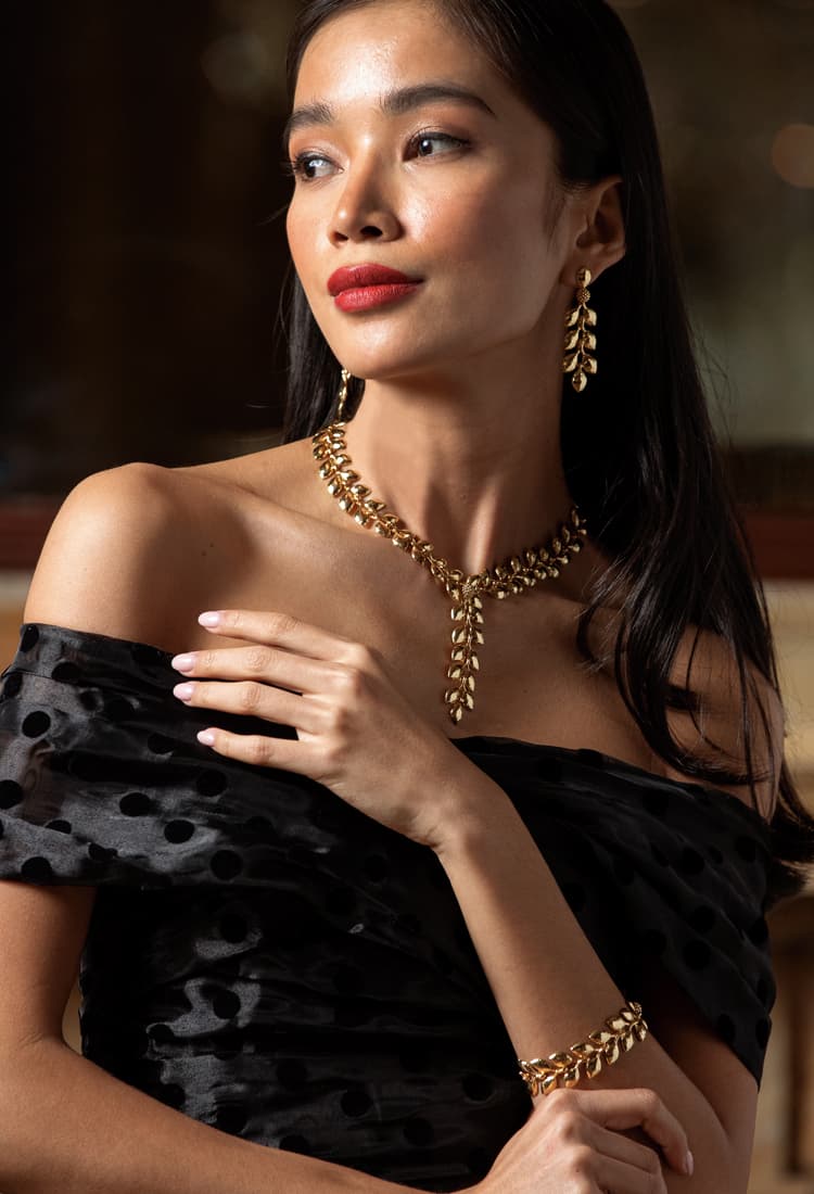 Woman wearing Golden Laurel Collection necklace and earrings