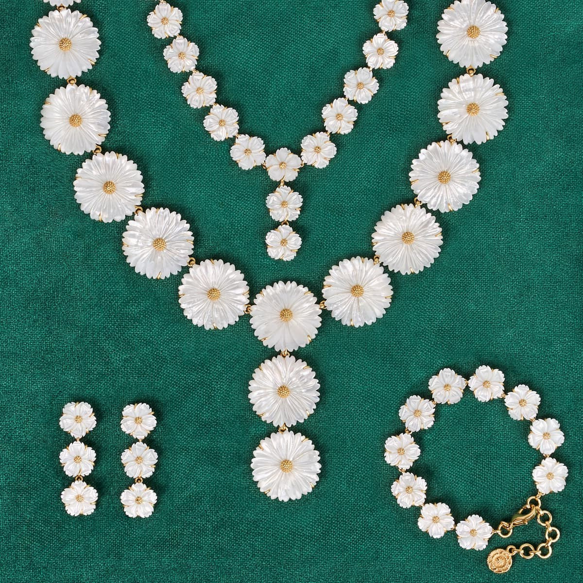 Floral necklace, earrings, and bracelet set on a green background