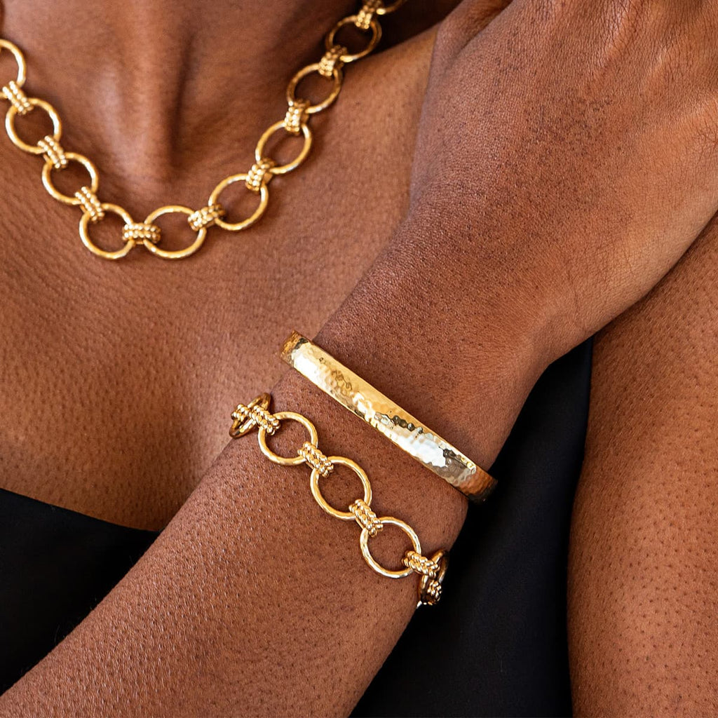 Gold chain necklace and bracelets on a person's arm