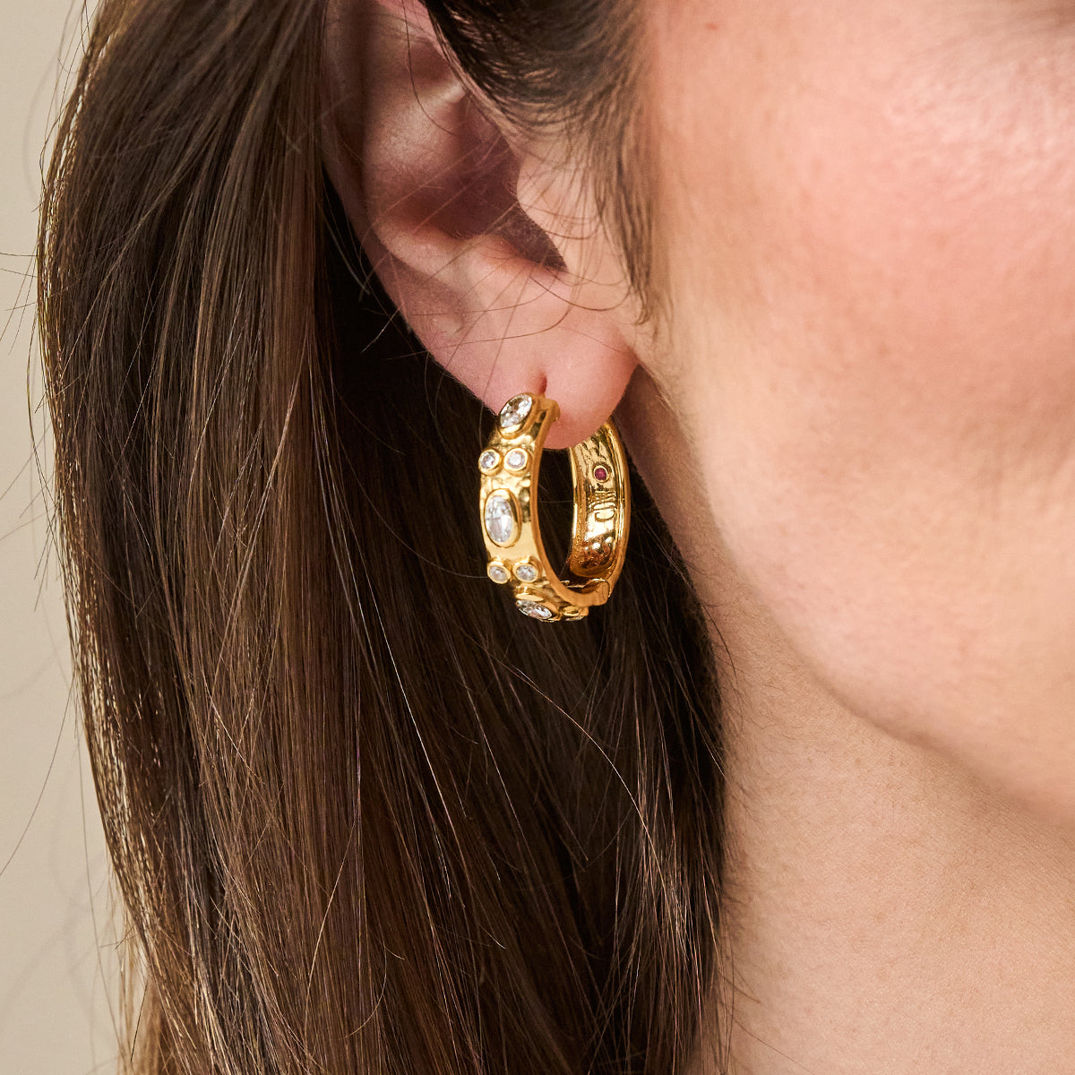 Maharani Huggie Hoop Earrings - Clear Cubic Zirconia close up on model ear