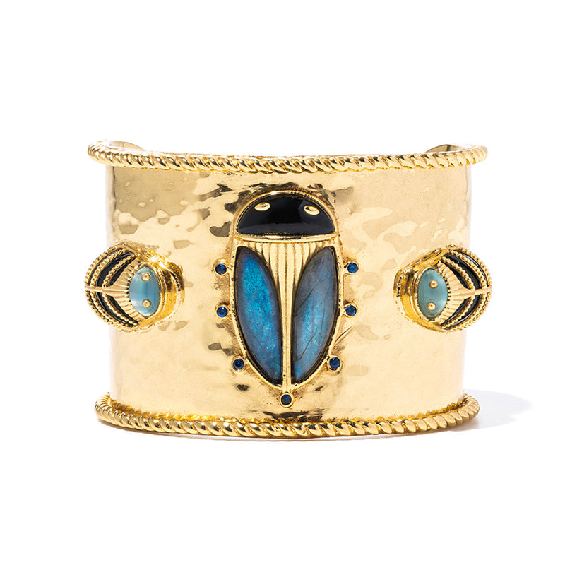 Exotic, regal and refined our stunning Scarab is an empowering talisman of renewal. Rendered with luminescent hand carved blue labradorite shell polished into noble wings, a black agate is set for the head and tiny feet sit rest purposefully atop an 18K flash gold plated brass cuff. The accompanying pair of Lovebugs are the catalyst and nourishment to the ongoing quest for re-newel.