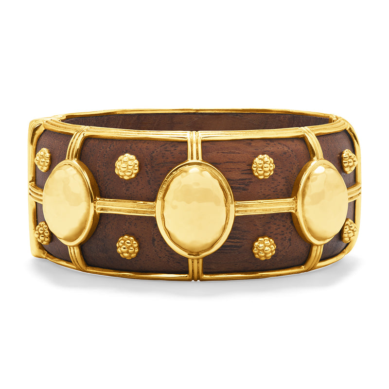 The Greek goddess personifying Earth, Gaia is strong, protective and nurturing. This statement piece is hand-carved in teak wood and accented with gleaming gold. A natural neutral, this bangle transitions beautifully from casual to formal and day to night and is ergonomically shaped for comfort around the wrist, with a durable spring hinge for easy on and off.